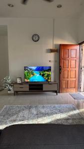 a living room with a flat screen tv on a wall at Ayu Homestay Kuantan in Beserah
