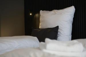 two white beds with black pillows in a room at 3-2-1meins Röntgen bis 3 Pers DTV 4 Sterne Parkplatz WLAN Self Check-in in Remscheid