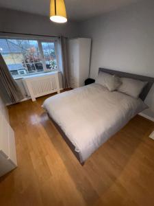 a bedroom with a white bed and a large window at Cosy room 4 T Gatwick in Crawley