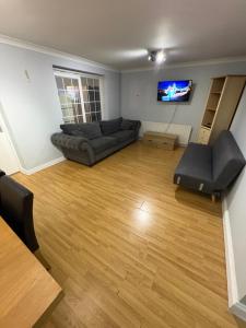 a living room with a couch and a flat screen tv at Cosy room 4 T Gatwick in Crawley