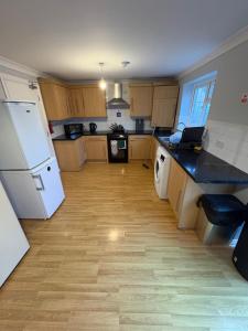 a kitchen with wooden floors and a white refrigerator at Cosy room 4 T Gatwick in Crawley