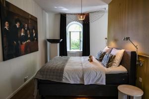 a bedroom with a large bed with a window at Kasteeltje Hattem in Roermond +26 photos