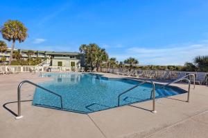 a large swimming pool with chairs and trees at SC217A: 217A Sea Cabin in Isle of Palms