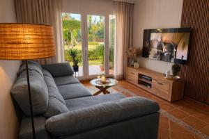 a living room with a blue couch and a television at Casa de Andres Mojácar in Mojácar