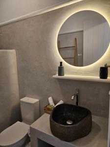 a bathroom with a black sink and a mirror at Parian Nissos Harmony Living in Angairiá +46 photos