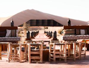 a group of chairs and tables and a tent at Desert Paradise Lodging in Merzouga +24 photos