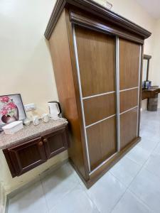 a bathroom with a large wooden closet with a counter at Petra 555 Rooms & Apartment in Wadi Musa