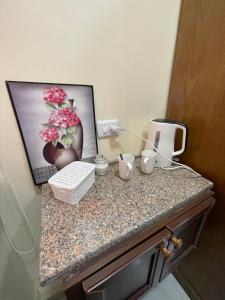 a desk with a computer and a picture of flowers on it at Petra 555 Rooms & Apartment in Wadi Musa