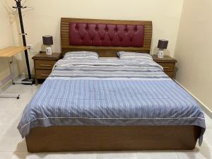 a bedroom with a large bed with a red headboard at Petra 555 Rooms & Apartment in Wadi Musa