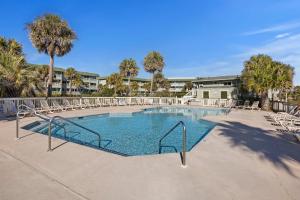 a large swimming pool with chairs and trees at SC206A: 206A Sea Cabin in Isle of Palms
