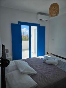 a bedroom with a large bed with blue doors at Parian Nissos Harmony Living in Angairiá