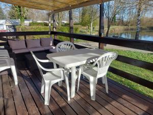 a white table and chairs on a wooden deck at mobile home A15 in Boofzheim