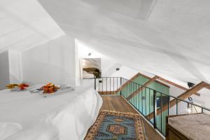 a white room with a bed and a staircase at La Chicchetta - Happy Rentals in Sauze d'Oulx