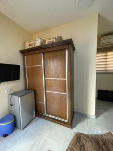 a room with a large wooden closet and a television at Petra 555 Rooms & Apartment in Wadi Musa