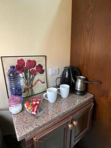 a kitchen counter with three cups and a water bottle at Petra 555 Rooms & Apartment in Wadi Musa +33 photos