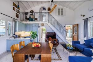 a kitchen and living room with a table and a staircase at Villa Sea Horizon in Skopelos Town