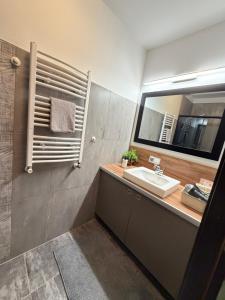a bathroom with a sink and a mirror at Apartament Zdrój Lądek in Lądek-Zdrój +18 photos