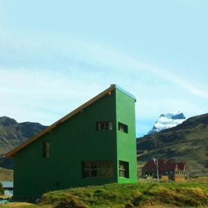 een groen gebouw met een berg op de achtergrond bij La Ribera - Sepúlveda 191 in El Chalten +43 foto's