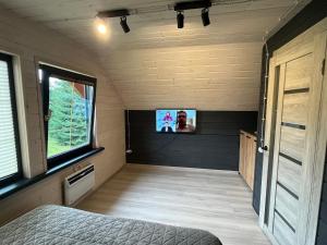 a room with a bed and a tv on the wall at Шале 1077 метрів над рівнем моря in Krivopolʼye