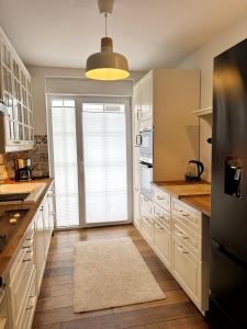 a kitchen with white cabinets and a large window at Ferienhaus Sandstrand in Cuxhaven +5 photos
