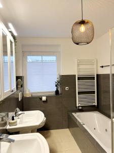 a bathroom with a sink and a tub and a toilet at Ferienhaus Sandstrand in Cuxhaven