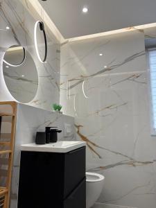 a bathroom with a toilet and a marble wall at Apartament Olesno Lux in Olesno +20 photos