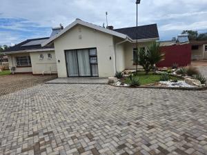 a house with a brick driveway in front of it at Tranquility Guest House in Bulawayo