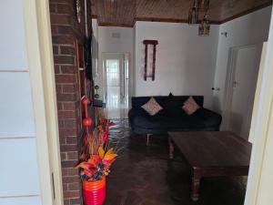 a living room with a couch and a table at Tranquility Guest House in Bulawayo