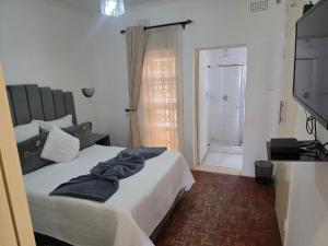 a bedroom with a bed with towels on it at Tranquility Guest House in Bulawayo
