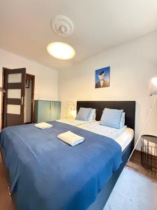 a bedroom with a large blue bed with towels on it at Apartament Zdrój Lądek in Lądek-Zdrój