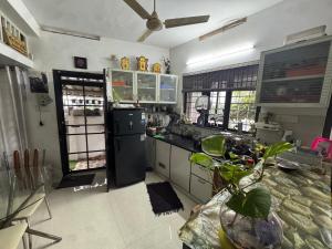 a kitchen with a black refrigerator and a window at Chaithritha Ladies Homestay in Trivandrum