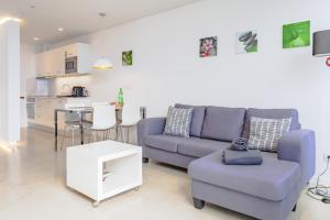 a living room with a blue couch and a table at Quinta Golfinho in Arco da Calheta