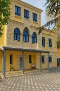 a large yellow building with windows on a street at Yellow House Suite in Majdal Shams