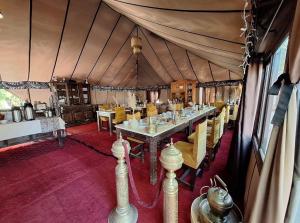 a dining room with a long table in a tent at Desert Paradise Lodging in Merzouga