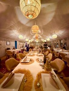 a large dining room with a long table and chairs at Desert Paradise Lodging in Merzouga