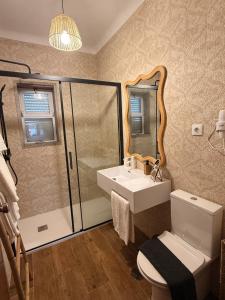 a bathroom with a sink and a toilet and a mirror at Alojamento Local S. Bartolomeu in Trancoso