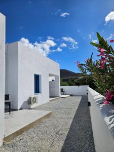a white house with a fence and flowers at Parian Nissos Harmony Living in Angairiá