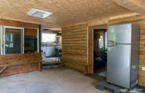 a kitchen with a refrigerator in a room with wooden walls at Ti kaz gogo in Salazie