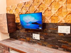 a flat screen tv on a brick wall at Kejriwals Vaikunth 35A in Bangalore