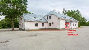 a white building with a blue roof and a red door at Raunex Apartment in Haapsalu