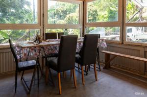 a dining room with a table and chairs and windows at Ti kaz gogo in Salazie