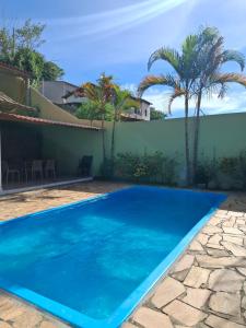 a blue swimming pool in front of a house at Casazul in Lavrinhas