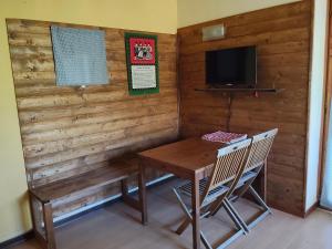ein Raum mit einer Holzwand mit einem Tisch und einem Fernseher in der Unterkunft la sequoia in Castagneto Po
