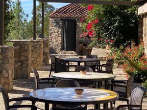 an outdoor patio with tables and chairs and flowers at Apartamentos en finca privada in La Borrega
