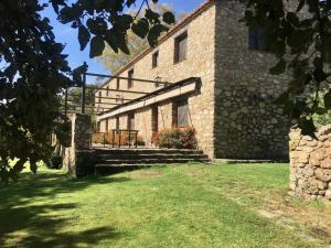 an external view of a stone building with a grass yard at Apartamentos en finca privada in La Borrega +4 photos