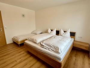 two beds in a room with wooden floors at Apartment Angela in Mittersill