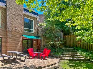 a patio with red chairs and a table at Hot Tub with Backyard Play Area in Toronto