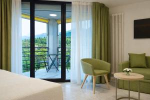 a hotel room with a bed and a balcony at Hotel Nessi Locarno in Locarno