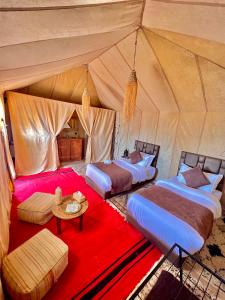 a room with three beds in a tent at Desert Paradise Lodging in Merzouga