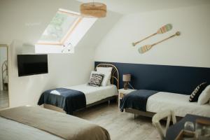 a room with two beds and a tv and a window at Parenthèse in Le Vivier-sur-Mer